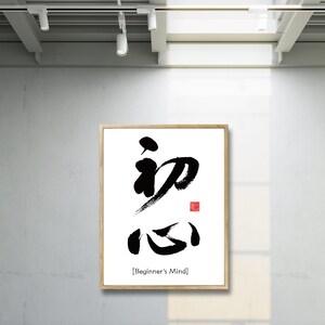 Pu&ograve; includere: Una stampa calligrafica in bianco e nero incorniciata dei caratteri giapponesi per "Beginner's Mind" con la traduzione inglese sotto. La stampa ha un sigillo rosso nell'angolo in alto a destra.