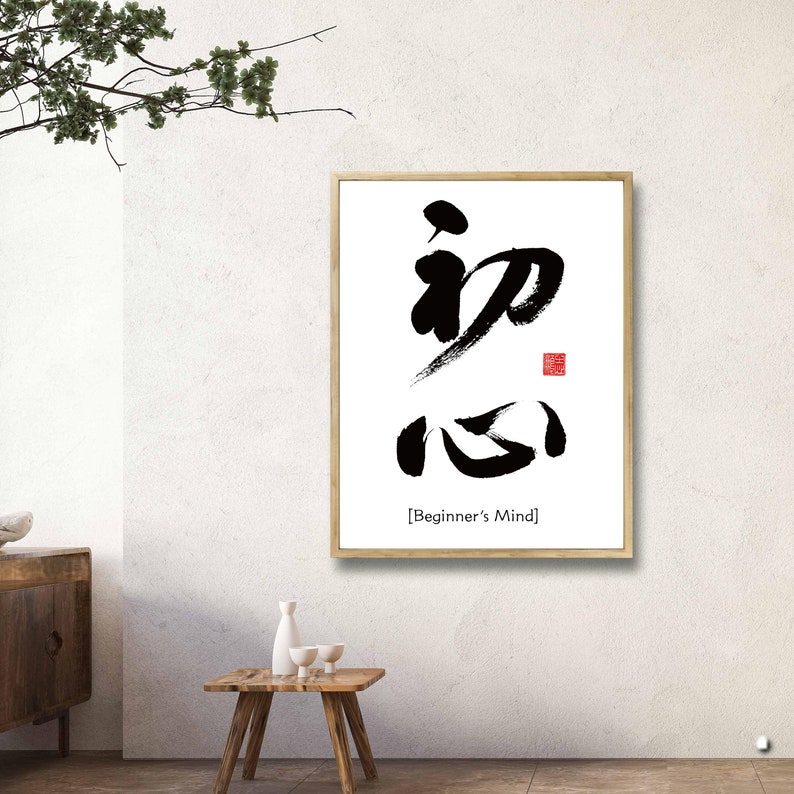 Pu&ograve; includere: Stampa d'arte calligrafica in bianco e nero con i caratteri giapponesi per "Mente del principiante" in una cornice di legno. I caratteri sono scritti in uno stile audace ed espressivo. La stampa &egrave; su sfondo bianco e ha un sigillo rosso.
