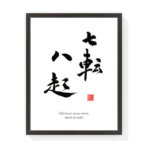 Puede incluir: Una impresión enmarcada con caligrafía negra sobre fondo blanco. La caligrafía presenta trazos negros audaces de caracteres japoneses. Debajo de los caracteres está el texto en inglés: "Fall down seven times, stand up eight."