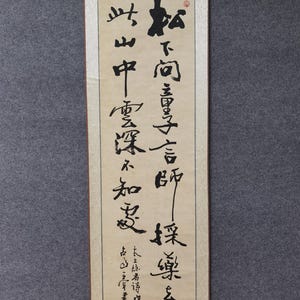 Peut inclure: Un rouleau japonais traditionnel avec une calligraphie noire sur papier crème. Le rouleau présente un texte vertical et un sceau rouge. La partie supérieure est de couleur beige clair. Le bas a une tige noire pour l'accrochage.