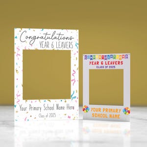 May include: Two white photo booth frames. The larger frame reads "Congratulations YEAR 6 LEAVERS" and "Your Primary School Name Here Class of 2025". The smaller frame says "CONGRATULATIONS YEAR 6 LEAVERS CLASS OF 2025" and "YOUR PRIMARY SCHOOL NAME". Confetti and balloons decorate the frames.