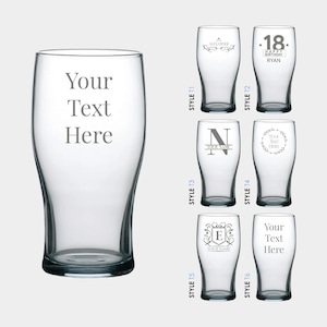 May include: Six different styles of personalised pint glasses. The glasses are clear and have a variety of designs, including a monogram, a wreath, and a simple text design. The text on the glasses reads "Your Text Here", "Alexander", "18. Happy Birthday Ryan", "N Your Name", "Your Text Here", "E Your Name", and "Your Text Here".