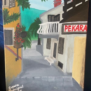 Puede incluir: Una pintura de una calle estrecha en un pueblo europeo. La calle est&aacute; bordeada de edificios, uno de los cuales tiene un letrero que dice "PEKARA." Los edificios est&aacute;n pintados en tonos de amarillo, blanco y marr&oacute;n. Hay &aacute;rboles y plantas en primer plano. La pintura est&aacute; firmada "Suzana Teodosjevic 2022."