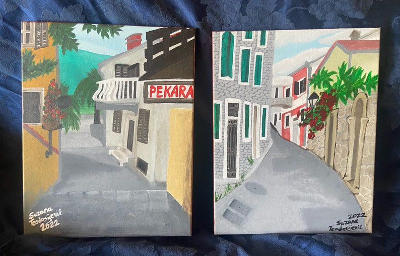 Puede incluir: Dos pinturas que representan calles estrechas y sinuosas en un pueblo europeo. La primera pintura muestra una panader&iacute;a con un letrero que dice "PEKARA". La segunda pintura muestra una calle con un muro de piedra y un edificio rojo. Ambas pinturas est&aacute;n firmadas por la artista, "Suzana Todosevic", y fechadas en "2022".