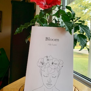 A line art style woman wearing a hibiscus flower crown- titled Bloom by Ally Loyns