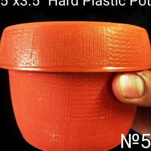 May include: A 5 inch by 3.5 inch orange hard plastic pot. The pot has a textured surface and is labeled "No. 5".