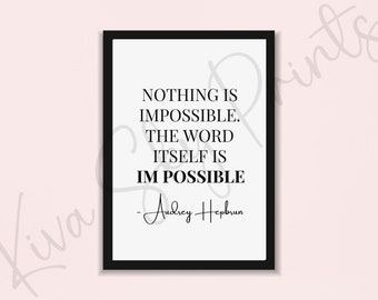 May include: A framed print with a white background and black text. The text reads "NOTHING IS IMPOSSIBLE. THE WORD ITSELF IS IM POSSIBLE" and is attributed to Audrey Hepburn. The frame is black.