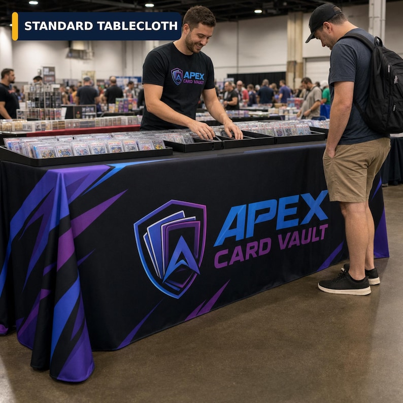 May include: A black tablecloth featuring a large blue and purple shield logo with the text APEX CARD VAULT in blue and purple lettering. The fabric has a dynamic abstract pattern of blue and purple streaks against a black background.