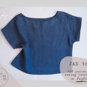 May include: A short-sleeved, indigo-blue top with a boat neck. The image includes text that reads "JAS top" and "PDF pattern & sewing tutorial in English." The top is available in sizes EU 34-52 and US 4-22.