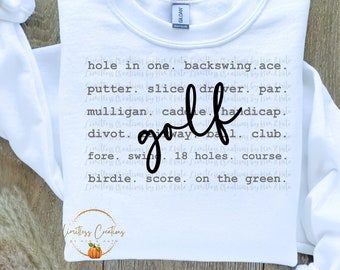 May include: White sweatshirt with the word "golf" written in cursive in black. The text "hole in one, backswing, ace, putter, slice, driver, par, mulligan, caddie, handicap, divot, fairway, ball, club, fore, swing, 18 holes, course, birdie, score, on the green" is printed in gray around the word "golf".