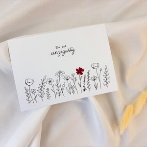 Postkarte - Du bist einzigartig - Blumenwiese in Schwarz-Weiß mit rotem Akzent auf mattem 300g/qm Papier im A6 Format - Grußkarte