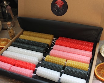May include: A set of 24 honeycomb beeswax candles in a box. The candles are in various colors, including white, black, red, pink, and yellow.