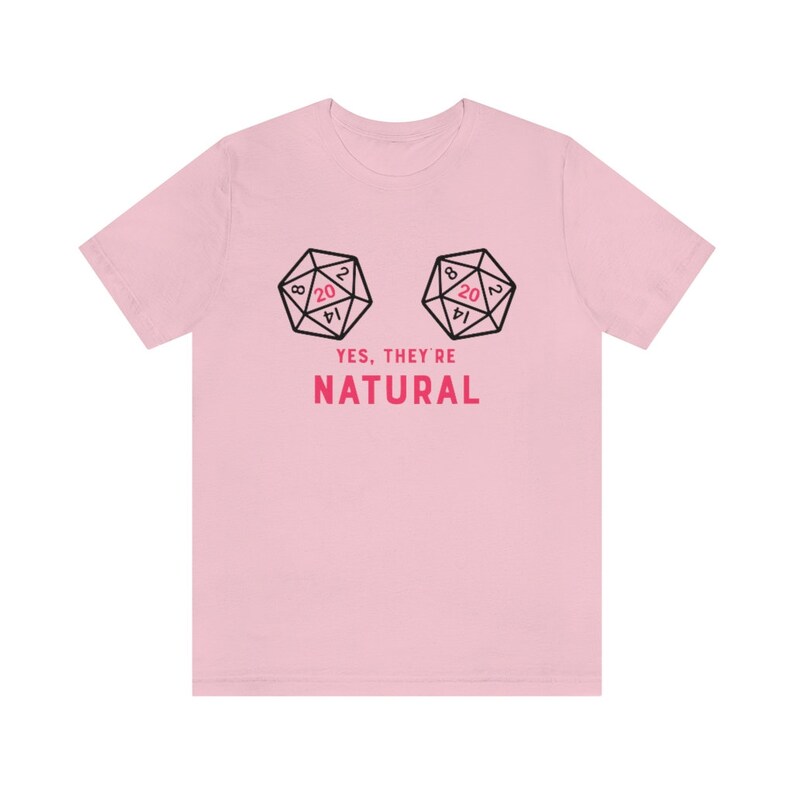 May include: Pink t-shirt with a graphic of two dice with the number 20 on the top face. The text "YES, THEY'RE NATURAL" is printed below the dice.