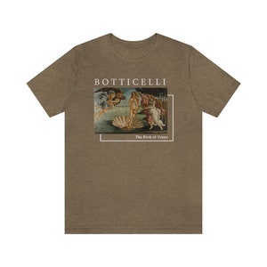 May include: A brown t-shirt with a white print of Sandro Botticelli's "The Birth of Venus" painting. The print includes the title of the painting and the artist's name.