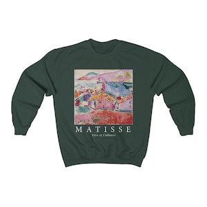 May include: Dark green sweatshirt with a print of a Matisse painting, "View of Collioure." The artwork shows a coastal scene with buildings and water. The word "MATISSE" and "View of Collioure" are printed below the artwork in white.