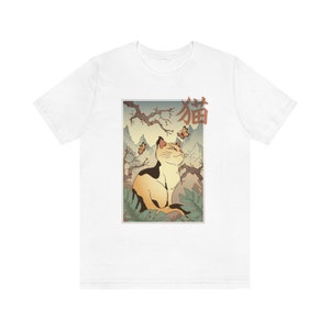 May include: White t-shirt with a Japanese-style illustration of a cat sitting in a forest with butterflies. The text "猫" is written in red on the shirt.