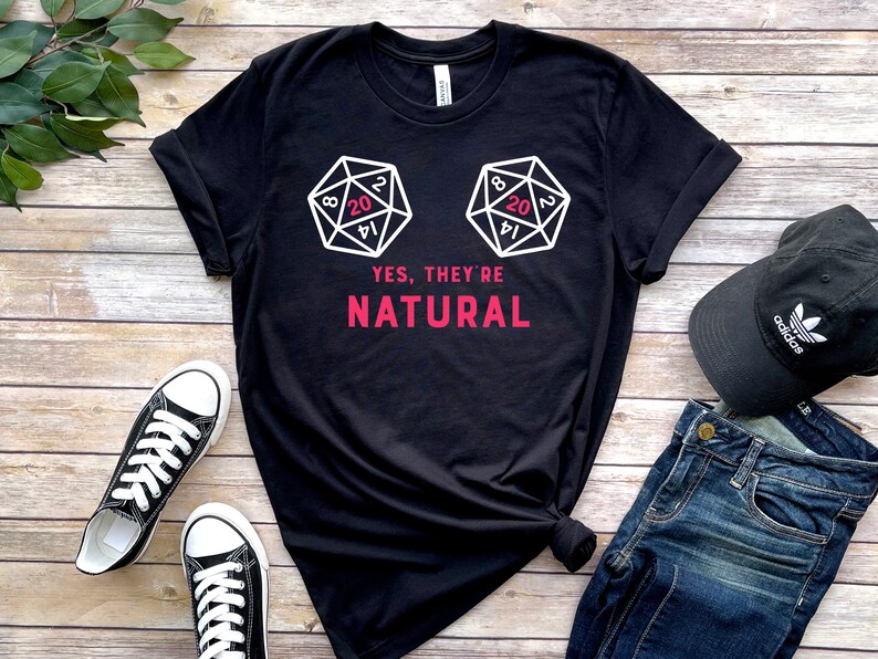 May include: Black t-shirt with a white graphic of two 20-sided dice and the text "YES, THEY'RE NATURAL".