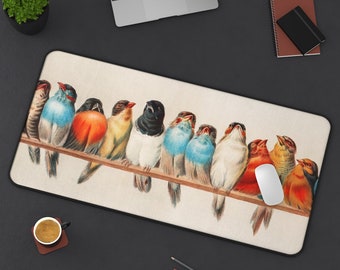 May include: A rectangular mouse pad featuring a vintage illustration of colorful birds perched on a branch. The birds have various colors, including blue, orange, yellow, and black. A white mouse is on the right side of the pad.