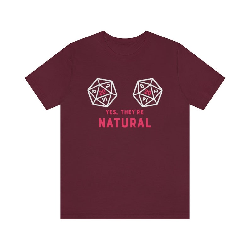 May include: A maroon t-shirt with a white graphic of two twenty-sided dice, with the text "YES, THEY'RE NATURAL" in pink.