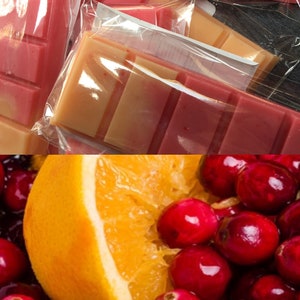 May include: A close-up of a sliced orange with red cranberries. The orange is bright yellow and the cranberries are a deep red.
