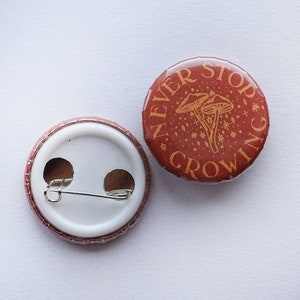 Insignia de botón roja de 25 mm Nunca dejes de crecer