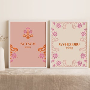 May include: Two framed prints with a pink and orange floral design. The left print says "Satnam" in English and Gurmukhi script. The right print says "Waheguru" in English and Gurmukhi script.
