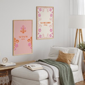 May include: Two framed prints with floral designs and text in orange and pink. The print on the left says "Satnam" in orange with a floral design in pink. The print on the right says "Waheguru" in orange with a floral design in pink.