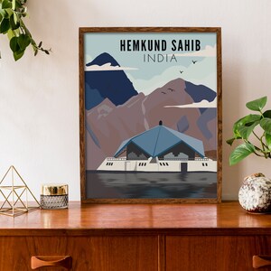 May include: A framed poster with a blue and white illustration of a building with mountains in the background. The text "HEMKUND SAHIB INDIA" is at the top of the poster.