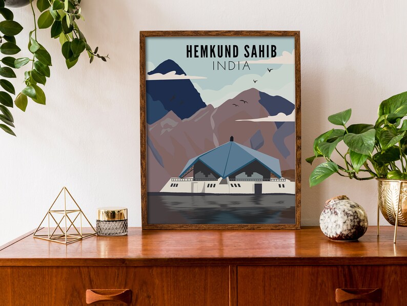 May include: A framed poster with a blue and white illustration of a building with mountains in the background. The text "HEMKUND SAHIB INDIA" is at the top of the poster.