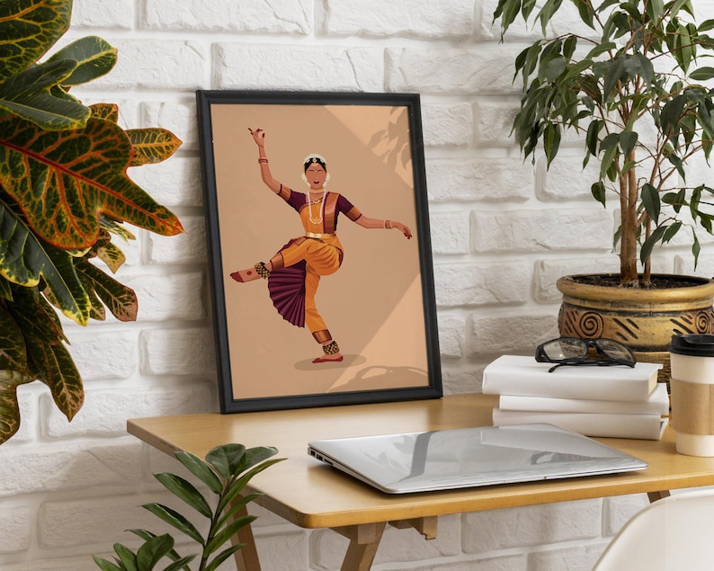 K&ouml;nnte beinhalten: Eine gerahmte Illustration einer Frau in einem gelben und violetten Outfit, die einen traditionellen indischen Tanz auff&uuml;hrt. Die Frau tr&auml;gt Schmuck und hat ihre Arme ausgestreckt. Der Hintergrund ist hellbraun.