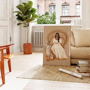 May include: A digital illustration of a woman in a white dress sitting on a peacock chair with a tiger beside her. The illustration is framed and hanging on a wall in a living room.