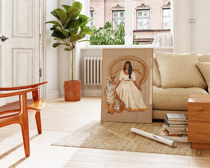 May include: A digital illustration of a woman in a white dress sitting on a peacock chair with a tiger beside her. The illustration is framed and hanging on a wall in a living room.