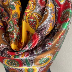 Pu&ograve; includere: Una sciarpa di seta colorata con un motivo paisley. La sciarpa presenta un mix di colori, tra cui oro, rosso, marrone e verde. Il design intricato &egrave; visibile su tutto il tessuto, creando un accessorio vibrante e accattivante.