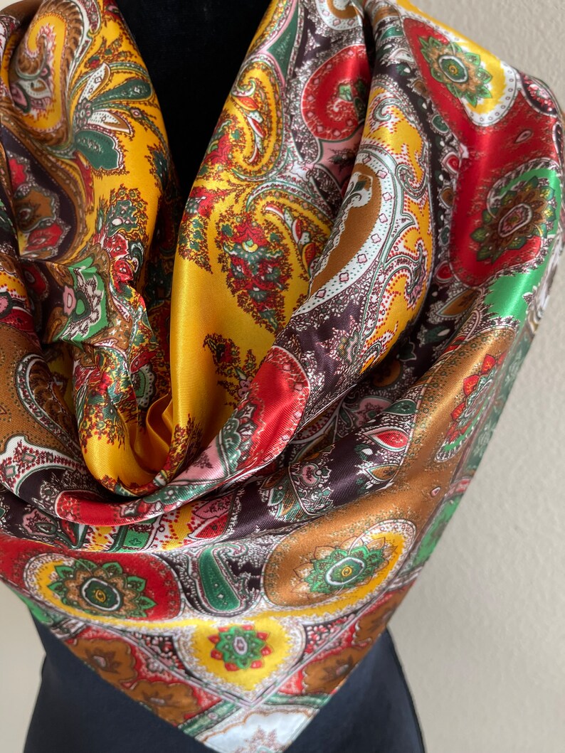 Pu&ograve; includere: Una sciarpa di seta colorata con un motivo paisley. La sciarpa presenta un mix di colori, tra cui oro, rosso, marrone e verde. Il design intricato &egrave; visibile su tutto il tessuto, creando un accessorio vibrante e accattivante.