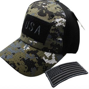 May include: A camouflage baseball cap with a black mesh back and a black patch that says "USA". The cap comes with a black and gray American flag patch.