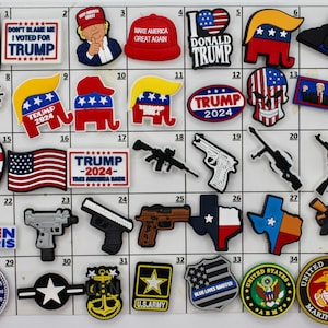 May include: A collection of 35 colorful, square, political themed shoe charms. The charms feature various political slogans, logos, and images, including American flags, guns, and the words "Trump", "Biden", and "Harris".