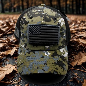May include: A camouflage baseball cap with a black mesh back and a curved brim. The cap features a black American flag patch on the front. The digital camo pattern includes shades of green, gray, and black.