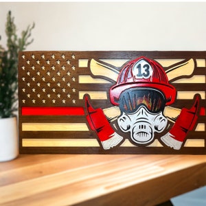 May include: Wooden American flag with a red stripe, featuring a firefighter helmet with a gas mask and crossed axes. The helmet has the number "13" on it.