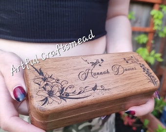 May include: A wooden box with a floral design and the name "Hannah Davies" engraved on the top. The box is made of dark wood and has a natural finish.