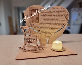 May include: Wooden heart-shaped memorial with a photo of a young boy, a rocking chair, and a candle holder. The heart has a message in Polish that reads "Kochana Mamo" and "Bernadette".