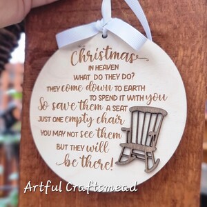 May include: A wooden Christmas ornament with a rocking chair cutout and the text "Christmas in heaven what do they do? They come down to earth to spend it with you. So save them a seat just one empty chair. You may not see them but they will be there! Artful Craftsmead."