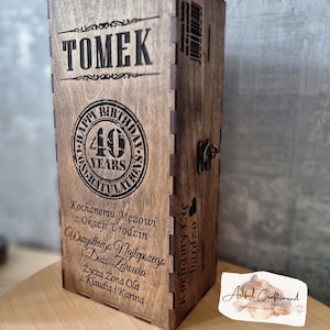 May include: A wooden box with a personalised message for Tomek's 40th birthday. The box is decorated with a circular design that says "Happy Birthday 40 Years Congratulations". The message on the box reads "Kochanemu Mężowi z Okazji Urodzin Wszystkiego Najlepszego i Dużo Zdrowia Życzą Żona Ola z Klaudią i Kariną Kochamy Cię bardzo".