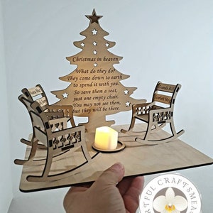 May include: A wooden Christmas tree ornament featuring two rocking chairs and a candle. The chairs are engraved with the names "Nana Mac", "Granda Bill", and "Scarlett Meg". The ornament includes the text "Christmas in heaven. What do they do? They come down to earth to spend it with you. So save them a seat, just one empty chair. You may not see them, but they will be there."