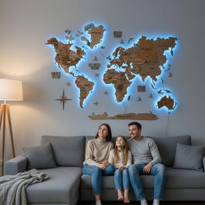 May include: A wooden world map with blue LED backlighting is mounted on a grey wall. The map is above a grey sofa where a family is seated. A compass and decorative airplanes are also on the wall.