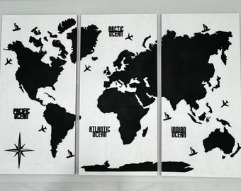 May include: A black and white world map wall art with three panels. The map shows the continents of North America, South America, Europe, Africa, Asia, Australia, and Antarctica. The oceans are labeled: Pacific Ocean, Atlantic Ocean, Indian Ocean, and Arctic Ocean. The map also includes small airplane and sailboat icons.