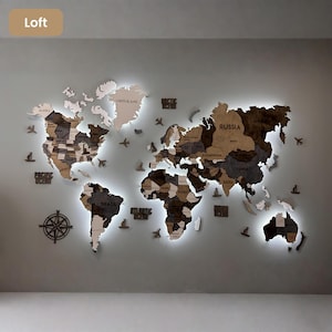 Op de afbeelding: Een grote houten wereldkaart als wanddecoratie met continenten in verschillende bruin- en grijstinten en ge&iuml;ntegreerde led-achtergrondverlichting. De kaart bevat uitgesneden landnamen, een kompasroos en kleine decoratieve houten vliegtuigen en schepen.