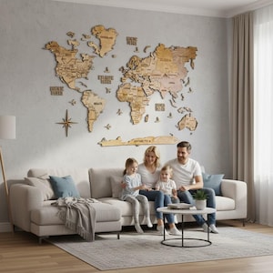 May include: A large, multi-layered wooden world map wall art installation featuring laser-cut continents, countries, and oceans. The map includes engraved text labels for major regions, oceans, and a compass rose, all mounted on a light gray wall.