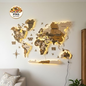 May include: A large wooden world map wall art piece featuring multi-tonal brown wood panels, integrated warm LED backlighting, and laser-cut country names. Includes decorative wooden airplanes, ships, a compass rose, and a circular badge stating PINS INCLUDED.