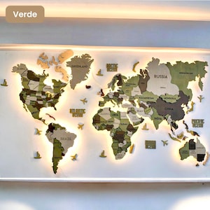Op de afbeelding: Een houten wereldkaart als wanddecoratie in verschillende tinten groen en bruin. De continenten zijn onderverdeeld met landnamen en grenzen. De kaart bevat uitsparingen voor de oceanen en is voorzien van warme achtergrondverlichting.