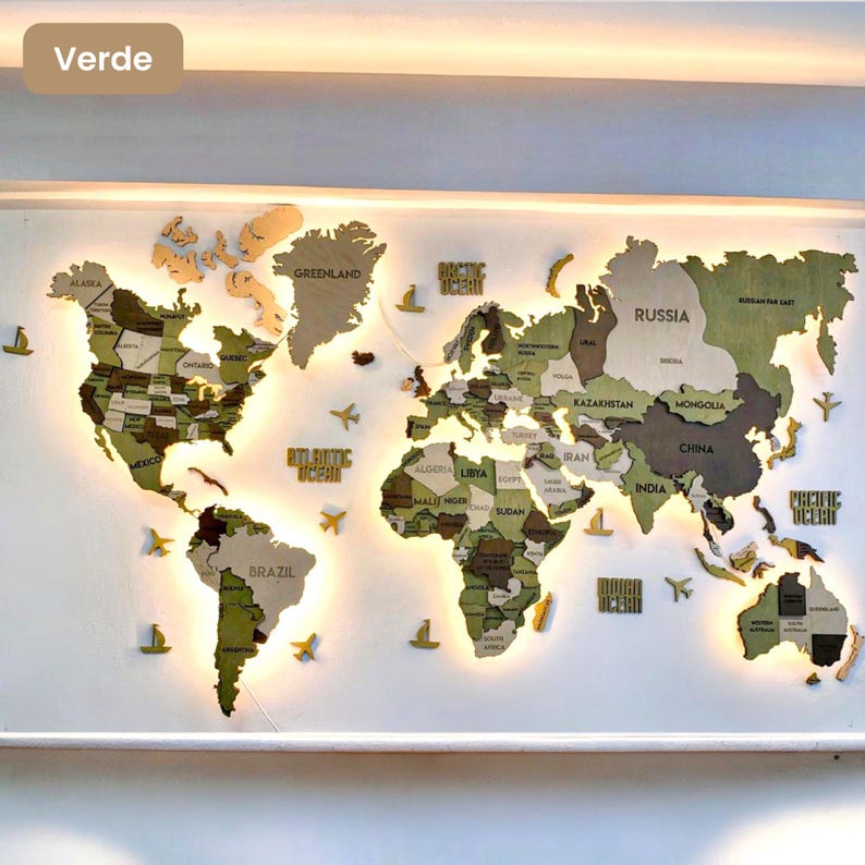 Op de afbeelding: Een houten wereldkaart als wanddecoratie in verschillende tinten groen en bruin. De continenten zijn onderverdeeld met landnamen en grenzen. De kaart bevat uitsparingen voor de oceanen en is voorzien van warme achtergrondverlichting.